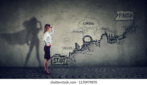 Business career challenges concept. Businesswoman imagining to be a super hero looking aspired making career plans - Powered by Shutterstock