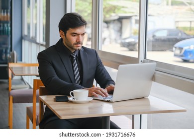 business caucasian man sitting in working in co working space near window