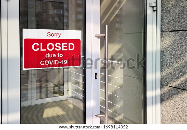 Business center closed due to COVID-19, sign\
with sorry in door. Stores, offices, other public places\
temporarily closed during coronavirus pandemic. Economy hit by\
corona virus. Lockdown\
concept.