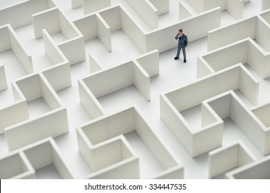 Business Challenge. A Businessman Navigating Through A Maze. Top View