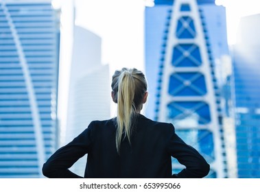 Business challenge. Confident businesswoman overlooking the city center high-rises. - Powered by Shutterstock