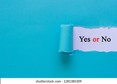 Business choice concept. Torn blue paper with Yes or No text on white background.