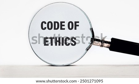 Business and code of ethics concept. Copy space. Concept words Code of ethics through a magnifying glass on a light gray background
