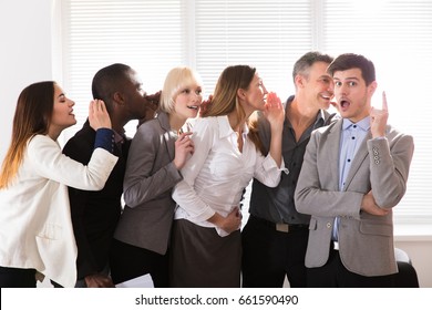 Business Colleague Whispering Secret Gossip To An Amazed Shocked Man With Wide Open Mouth - Powered by Shutterstock