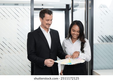 Business colleagues discussing color palette options during a creative meeting in a modern office - Powered by Shutterstock