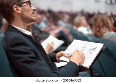 business colleagues with financial schedules sitting in the conference hall. - Powered by Shutterstock