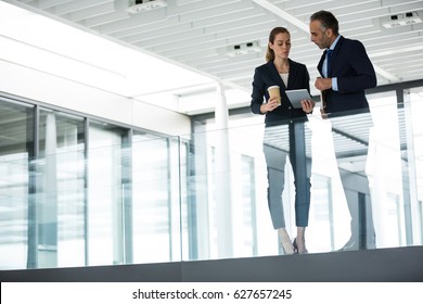 Business colleagues interacting with each other in office corridor - Powered by Shutterstock