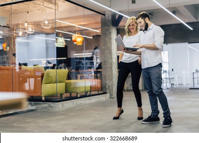 Business colleagues laughing while looking at the laptop