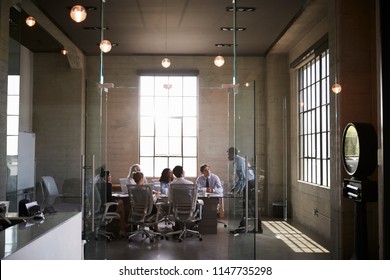 Business colleagues at a meeting in a glass walled boardroom - Shutterstock ID 1147735298