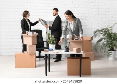 Business colleagues packing things in light office on moving day - Powered by Shutterstock