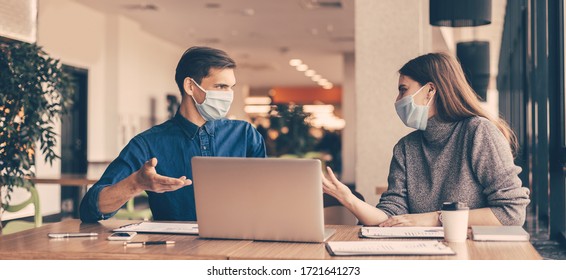 business colleagues in protective masks sitting at the office Desk. - Powered by Shutterstock