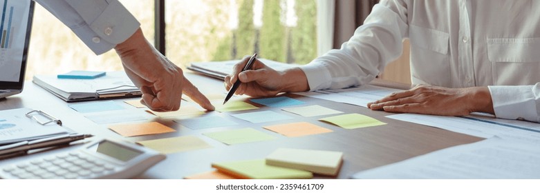 Business colleagues reading data in sticky notes to brainstorming and coworking about new business. - Powered by Shutterstock