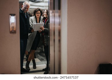 Business colleagues reviewing documents together in elevator. - Powered by Shutterstock