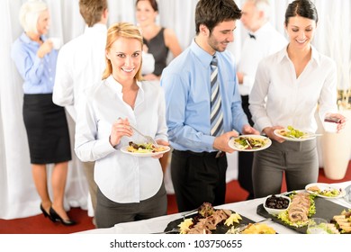 Business Colleagues Serve Themselves At Buffet Catering Service Company Event