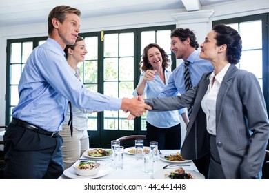 Business Colleagues Shaking Hands After A Successful Lunch Meeting At Restaurant