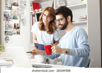 Business Colleagues Sitting At Desk And Working On Small Architect Studio. 