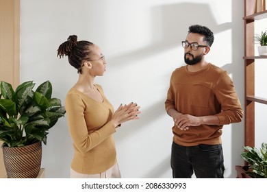 Business Colleagues Standing In Cozy Modern Office And Discussing Upcoming Meeting