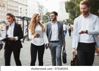 Business Colleagues Walking And Talking On City Streets