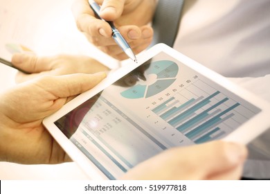 Business colleagues working and analyzing financial figures on a digital tablet - Shutterstock ID 519977818