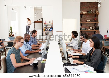 Business colleagues working at a busy open plan office