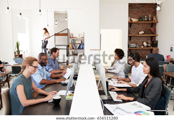 Business\
colleagues working at a busy open plan\
office