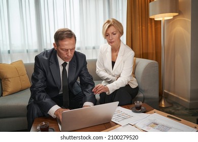 Business Colleagues Working On Laptop In Hotel Room