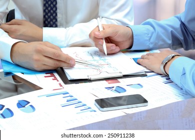 business colleagues working together and analyzing financial figures on a graphs - Shutterstock ID 250911238