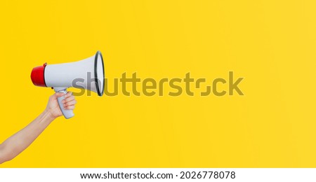 Business Communication and Marketing Concept : Female hand holding megaphone for announcement and advertisement.
