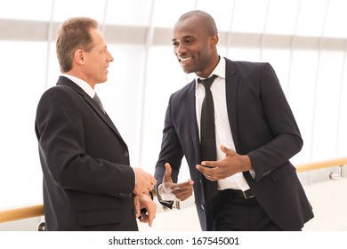 Business Communication. Two Cheerful Business Men Talking To Each Other And Gesturing