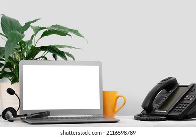 Business And Communications. Laptop Mockup Screen And Voip Phone In The Office. Conference Call, Contact Us Or Hotline. IP Telephony, Telemarketing. Help Desk Or Call Centre. Work From Home