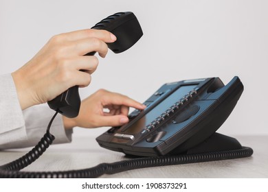 Business And Communications. Using Voip Phone In The Office, Close Up Of Hand With Receiver. Conference Call, Contact Us Or Hotline. IP Telephony, Telemarketing. Help Desk Or Call Centre