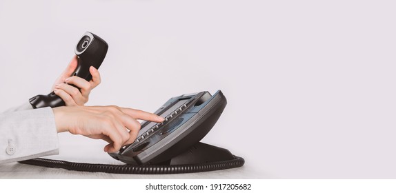 business and communications. Using voip phone in the office, close up of hand with receiver. Conference call, contact us or hotline. IP telephony, Telemarketing. Help desk or call centre. Copy space