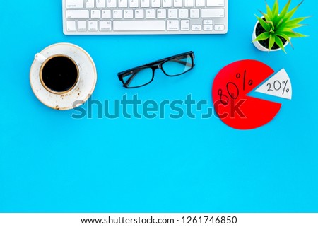 Business competition. Office desk with keyboard, coffee and pie-chart with market share. Monopoly. Blue office background top view mock up