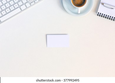 Business Composition With Cropped Computer Keyboard Notepad And Pen Cup Of Coffee And Blank Business Card On White Office Desk