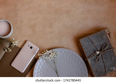 Business Composition In Retro Style In Brown Processing Mobile Phone Book Notepad Tableware Coffee Dried Flowers On Kraft Paper