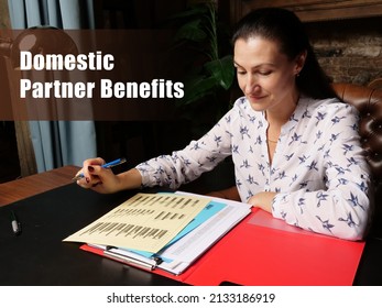 Business Concept About Domestic Partner Benefits Female Office Workers With Yellow Shirt Holding And Writing Documents On Office Desk
