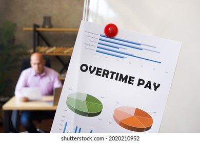 Business Concept About OVERTIME PAY With Sign On The Financial Document. Businessman Working With Documents In The Background. 
