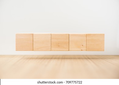 Business concept - Abstract geometric real floating wooden cube on grey background and it's not 3D render, float on wood floor white background for display or montage word.