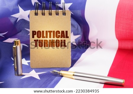 Business concept. Against the background of the American flag is a notepad with the inscription - political turmoil