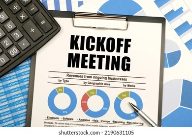 Business Concept. Against The Background Of Charts And Graphs, There Are Office Items And A Tablet With Documents And The Inscription - Kickoff Meeting