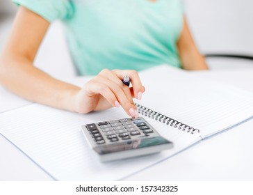 business concept - businesswoman working with calculator in office