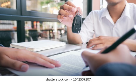Business concept, car insurance, sell and buy car, car financing, car key for Vehicle Sales Agreement. New carowners are taking keys from male salespeople. 