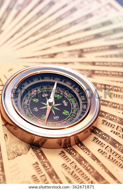 Business concept. Closeup of compass on USA dollar\
bank notes