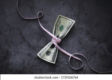 Business Concept. The Depreciation Of National Currency. Hundred Dollar Bill. Inflation And Stagnation. Tighten The Hundred Dollar Bill With A Measuring Chain.