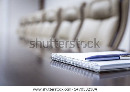 Business concept with empty meetingroom, paper agenda and pen. vintage tone