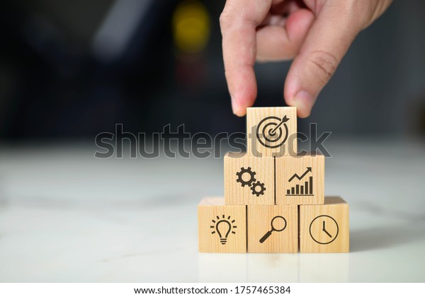 Business concept growth success process, Close up\
man hand arranging wood block with icon business strategy and\
Action plan, copy\
space.