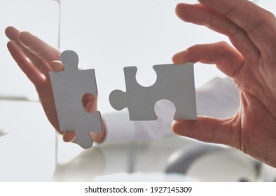 Business concept: Hand holding two pieces of a puzzle - Shutterstock ID 1927145309
