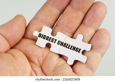 Business Concept. In The Hand Of A Man Are Puzzles With The Inscription - Biggest Challenge