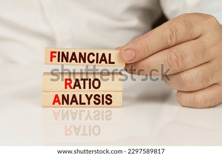 Business concept. In the hands of a person and on a reflective surface are wooden blocks with the inscription - Financial Ratio Analysis