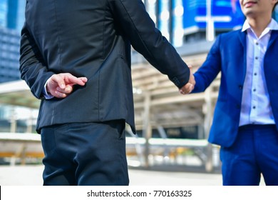 Business concept hypocrisy, Young businessmen shake hands with fraudulent models. - Shutterstock ID 770163325